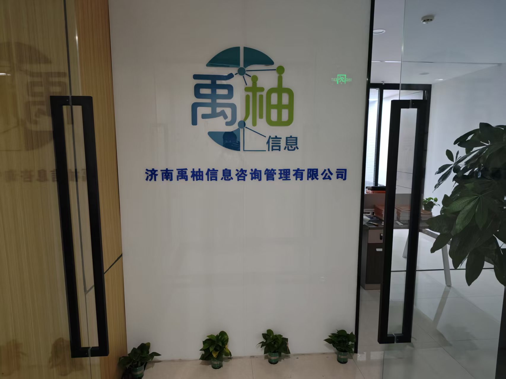 禹柚信息办公环境，墙面展示济南禹柚信息咨询管理有限公司名称